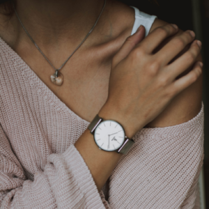 woman wearing watch hugging self, wanting more from life